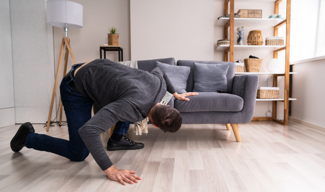 Searcher looking under his couch